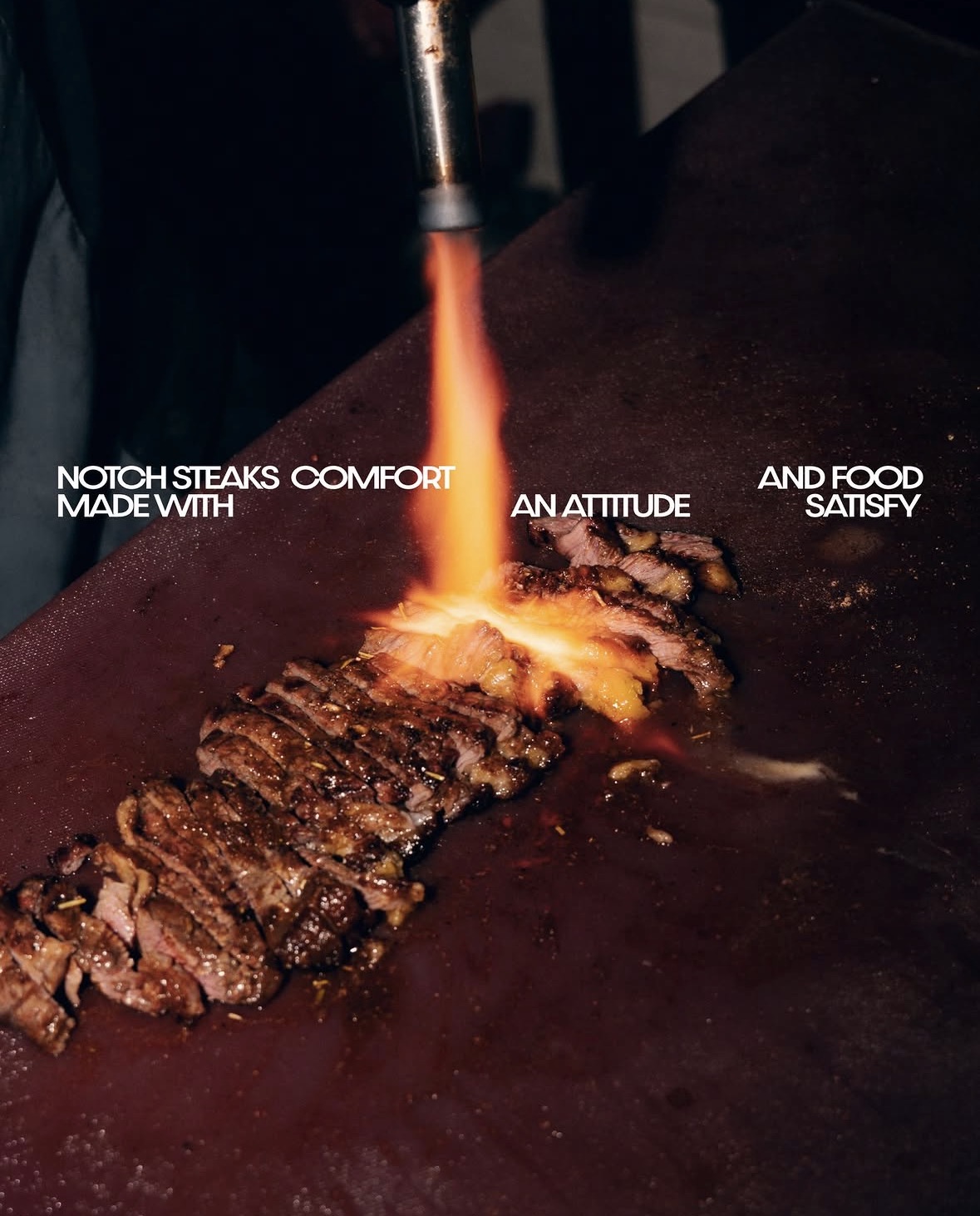 NOTCH steak being finished with flame